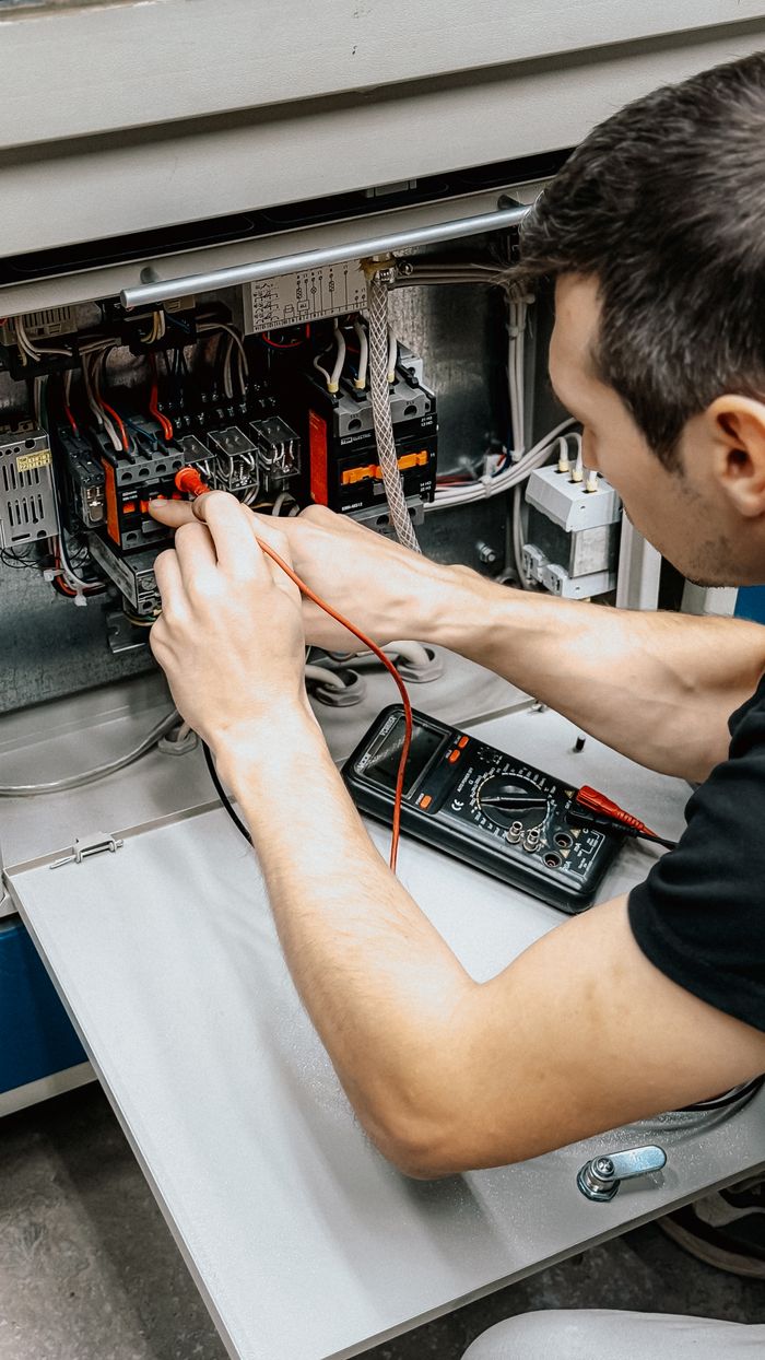 contact-hero An electrician uses a multimeter to test and diagnose connections in an open electrical panel.
