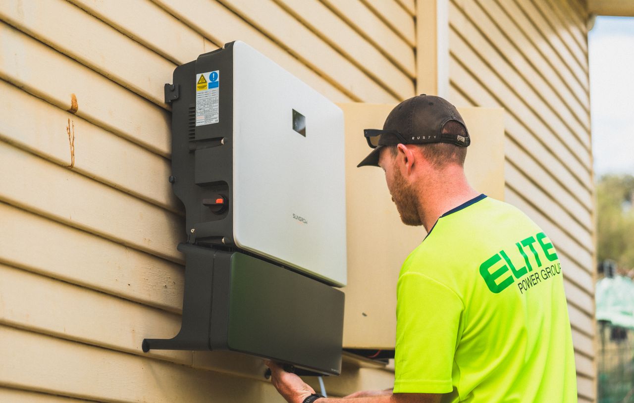services-01 A skilled technician working on the installation of a solar inverter system outdoors. Energy efficiency solution.