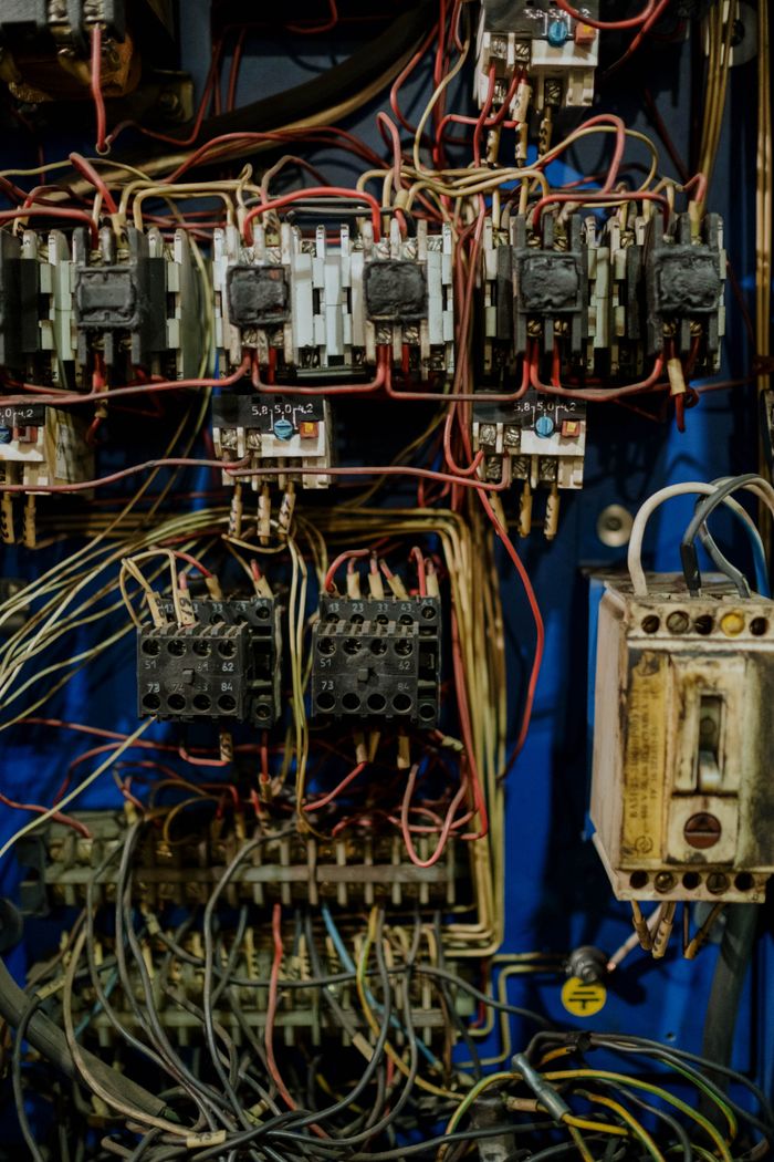 services-02 Close-up view of an intricate electrical wiring panel with various cables and connectors.